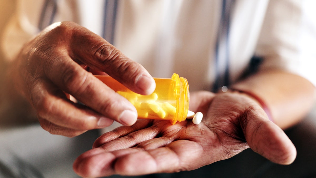 Hands, pills and bottle first for people with drugs, routine and health programming at home. Large patient, container and pharmaceutical product for supplements, well -being or retirement benefits